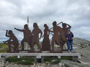 author standing next to life size metal silhouettes of 6 Vikings
